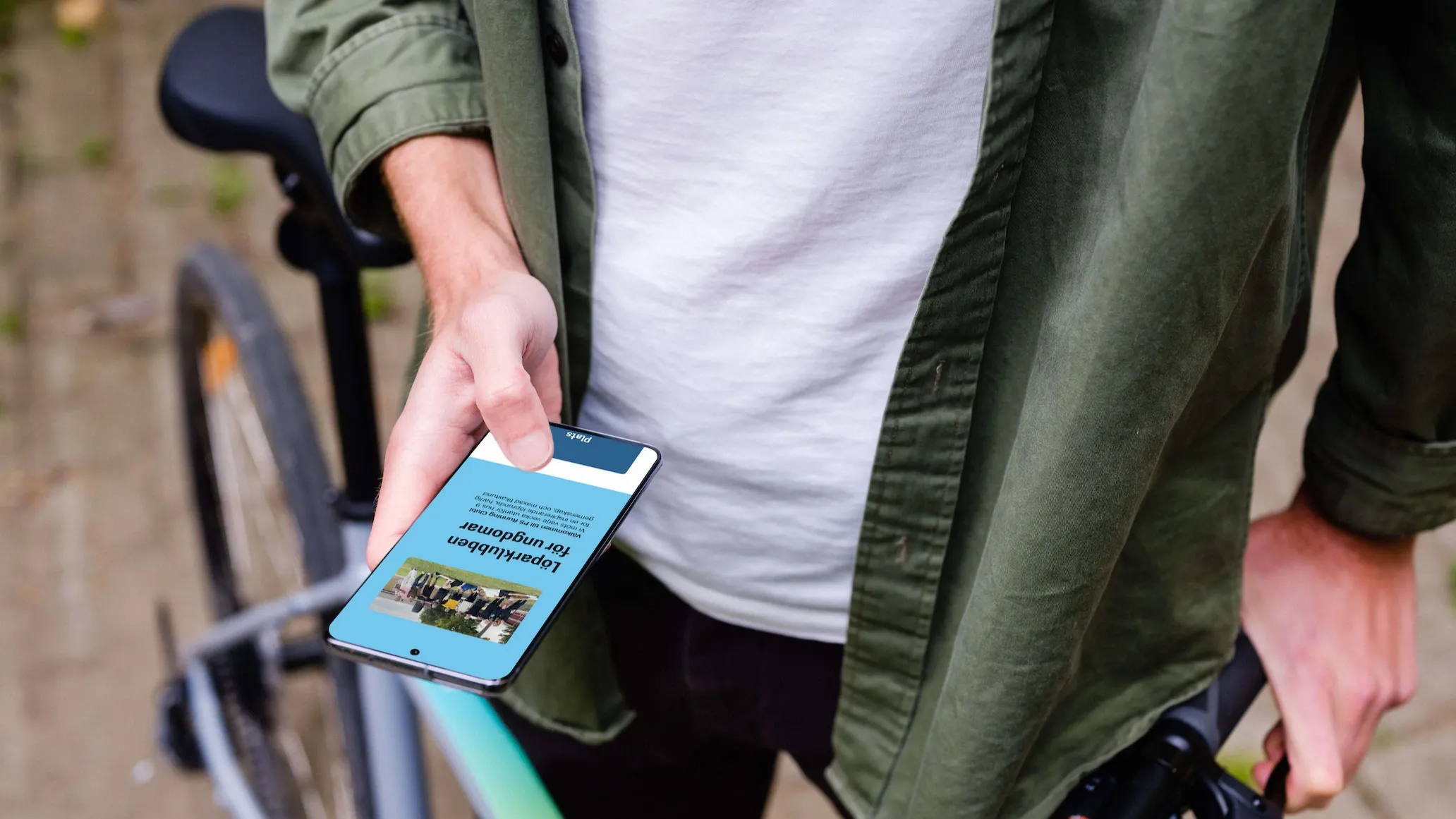 Person holding phone with the PS Running Club website open. It features a photo of the members